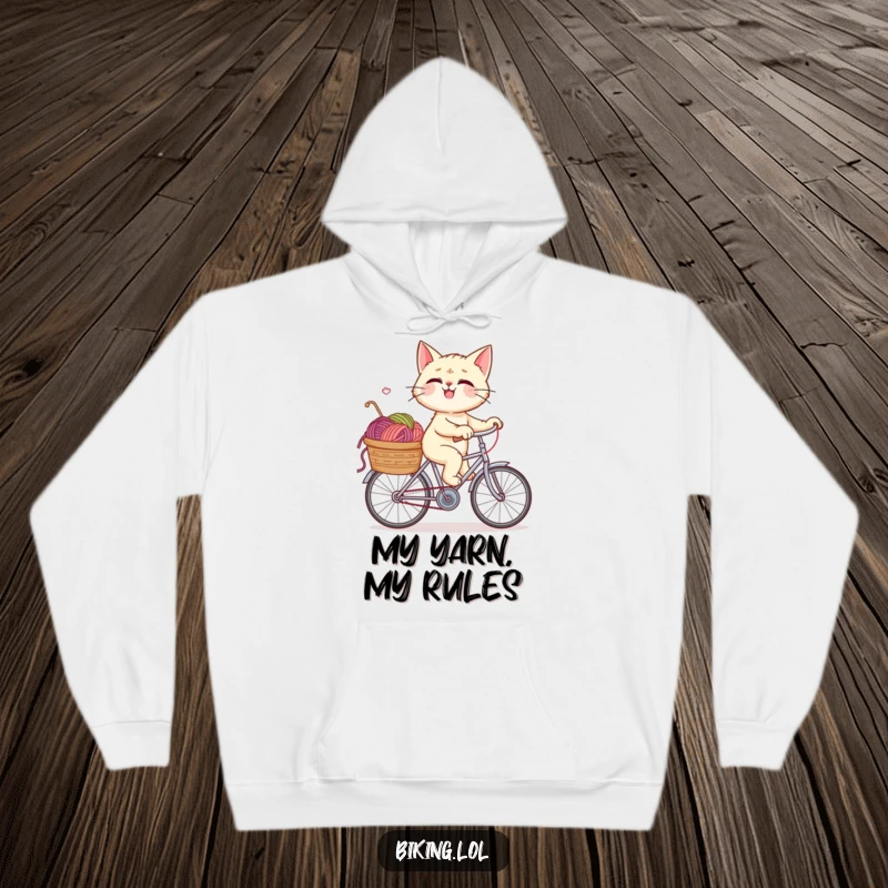 Funny hoodie showcasing a giggling cat on a bike, its yarn-filled basket a symbol of playful chaos and hilarious adventure.