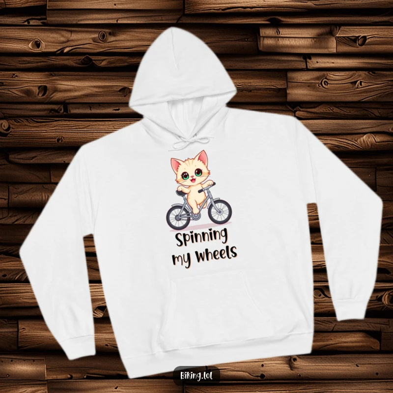 Funny kitten hoodie, delighted kitten with wide eyes balancing on a stationary bicycle crank, looking cute and funny.