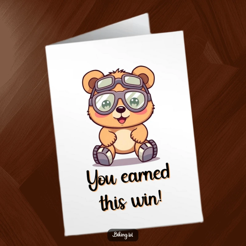 Funny free printable congratulations card, a happy bear with oversized goggles, pedaling a bike with great effort, acknowledging effort.