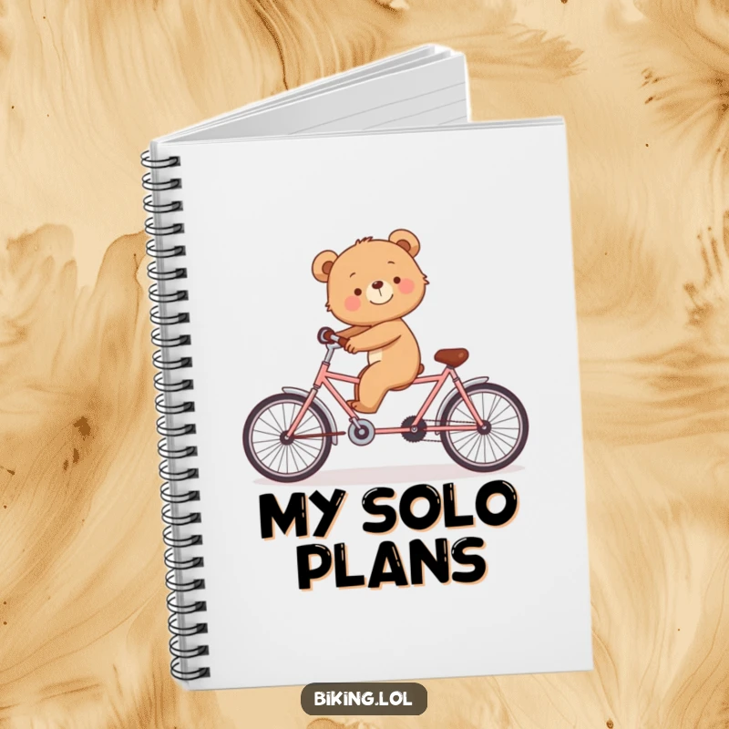 Funny notebook cover with a smiling bear cub struggling to balance on a tandem bicycle alone.